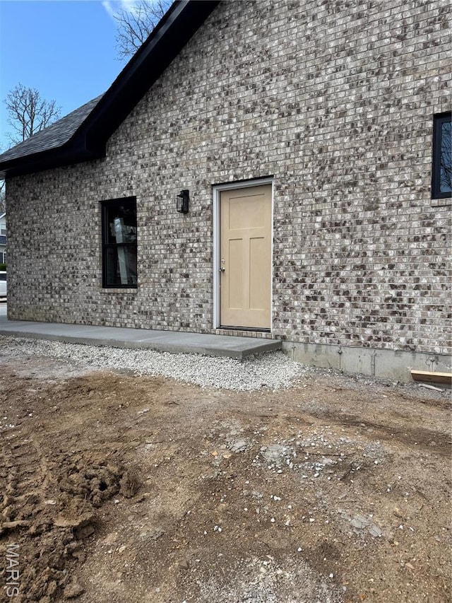 back of property featuring brick siding