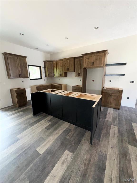 kitchen featuring a kitchen island, wood finished floors, and recessed lighting