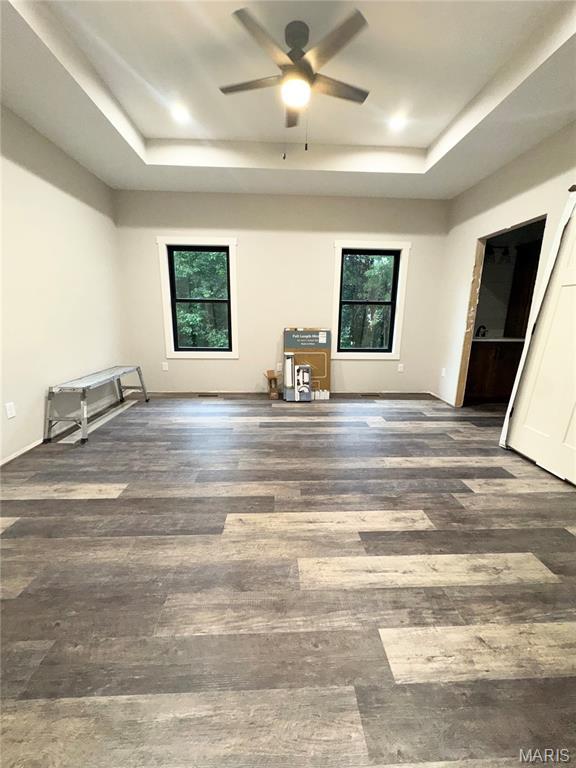 615 Scottsvale Dr, Rolla, MO 65401 - unfurnished bedroom with a raised ceiling, multiple windows, and wood finished floors