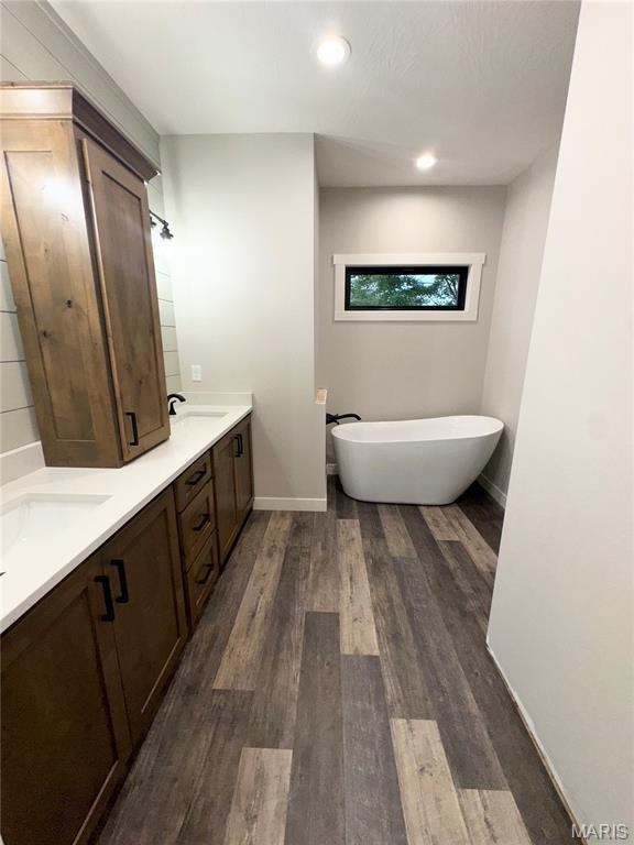 615 Scottsvale Dr, Rolla, MO 65401 - bathroom featuring double vanity, a soaking tub, wood finished floors, baseboards, and recessed lighting