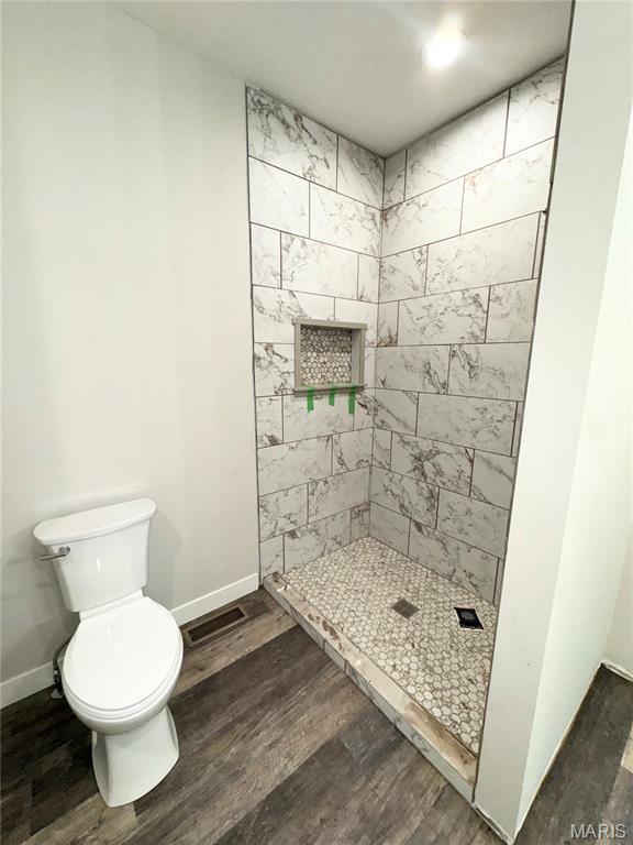 615 Scottsvale Dr, Rolla, MO 65401 - full bath with wood finished floors, tiled shower, toilet, and baseboards