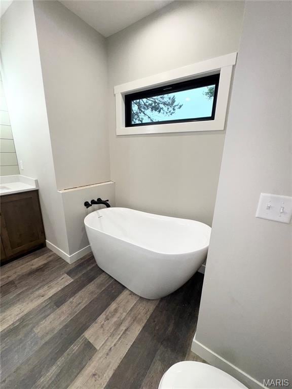 615 Scottsvale Dr, Rolla, MO 65401 - full bathroom featuring a soaking tub, wood finished floors, vanity, baseboards, and toilet