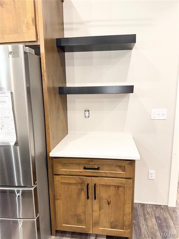 615 Scottsvale Dr, Rolla, MO 65401 - detailed view of freestanding refrigerator, open shelves, dark wood-type flooring, and brown cabinets