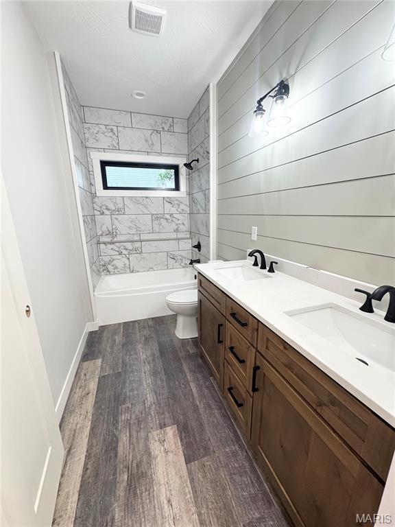 615 Scottsvale Dr, Rolla, MO 65401 - bathroom with bathtub / shower combination, double vanity, wood finished floors, and toilet
