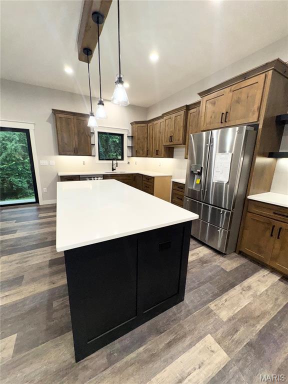 615 Scottsvale Dr, Rolla, MO 65401 - kitchen featuring stainless steel fridge, a kitchen island, a sink, dark wood finished floors, and light countertops