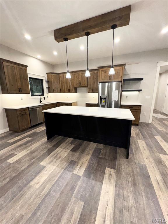 615 Scottsvale Dr, Rolla, MO 65401 - kitchen with stainless steel appliances, open shelves, a kitchen island, light countertops, and wood finished floors