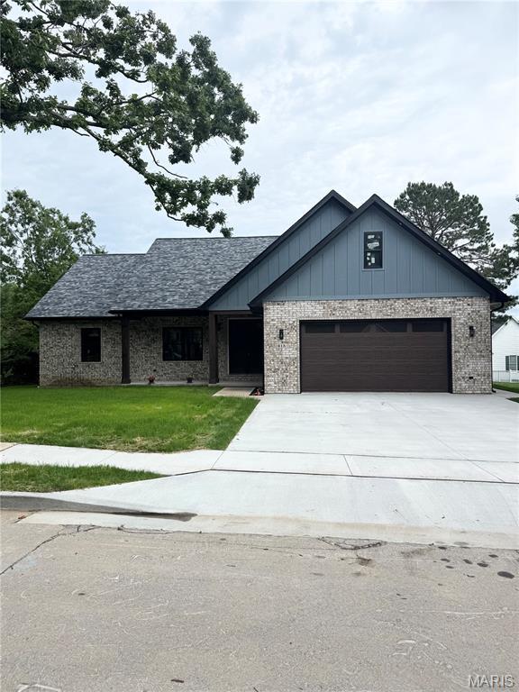 615 Scottsvale Dr, Rolla, MO 65401 - view of front facade with driveway, a garage, a front yard, brick siding, and board and batten siding