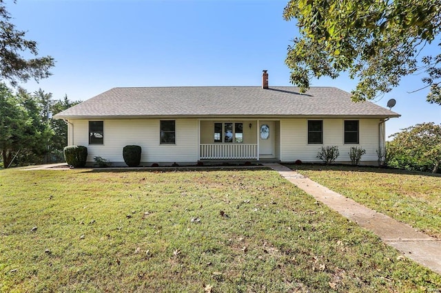ranch-style house with covered porch, a front lawn, and a chimney