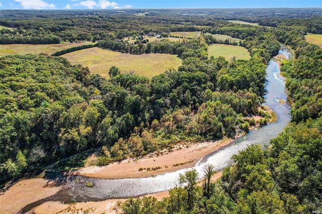 drone / aerial view of a heavily wooded area and a nearby body of water