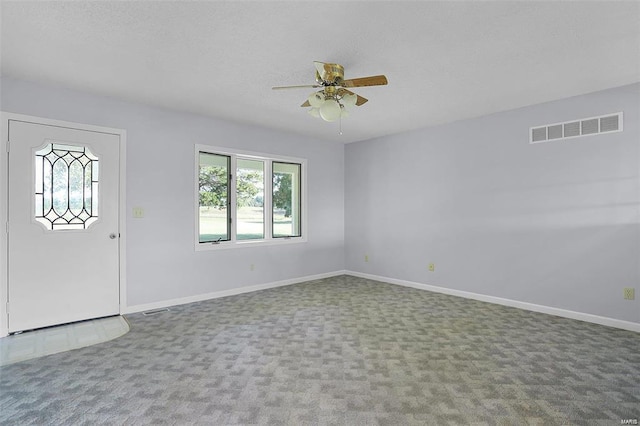 carpeted entryway featuring plenty of natural light, a ceiling fan, and baseboards