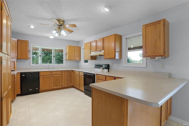 kitchen with black appliances, a peninsula, under cabinet range hood, plenty of natural light, and a textured ceiling