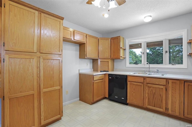 kitchen featuring black dishwasher, a sink, light flooring, light countertops, and a textured ceiling