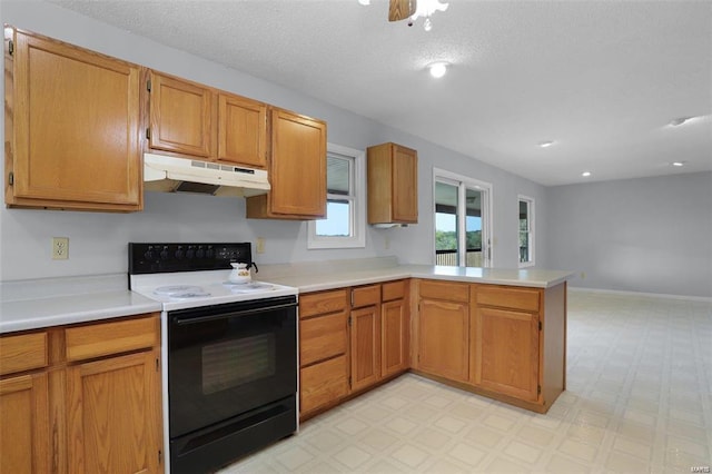 kitchen with range with electric stovetop, under cabinet range hood, a peninsula, light countertops, and recessed lighting