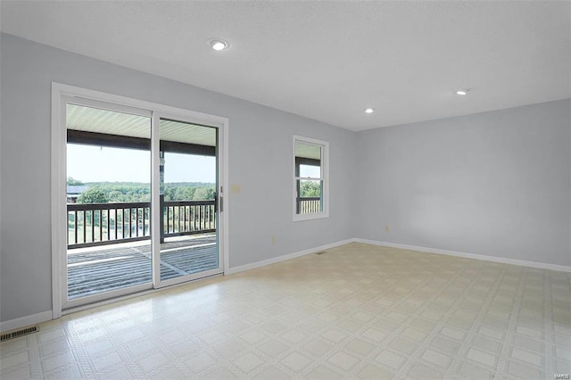 empty room with baseboards, recessed lighting, and light floors