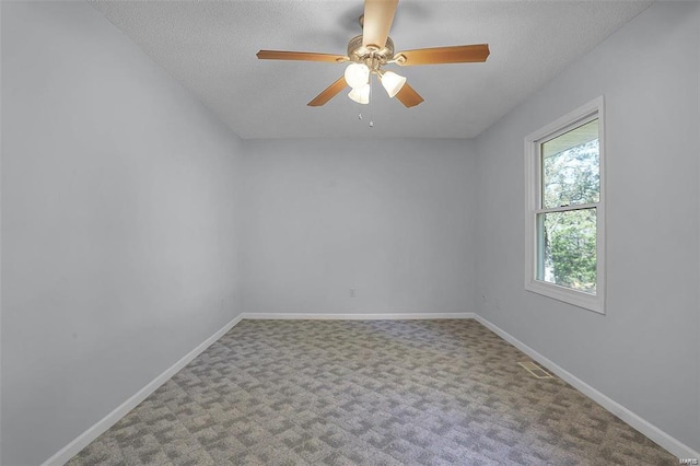 carpeted empty room with baseboards, a textured ceiling, and a ceiling fan
