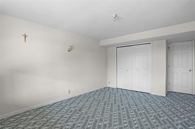 unfurnished bedroom featuring baseboards, carpet floors, and a closet