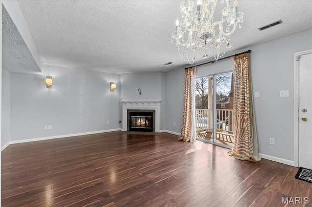 1436 Peacock Ln, Saint Louis, MO 63144 - unfurnished living room featuring a textured ceiling, wood finished floors, a chandelier, a fireplace with flush hearth, and baseboards