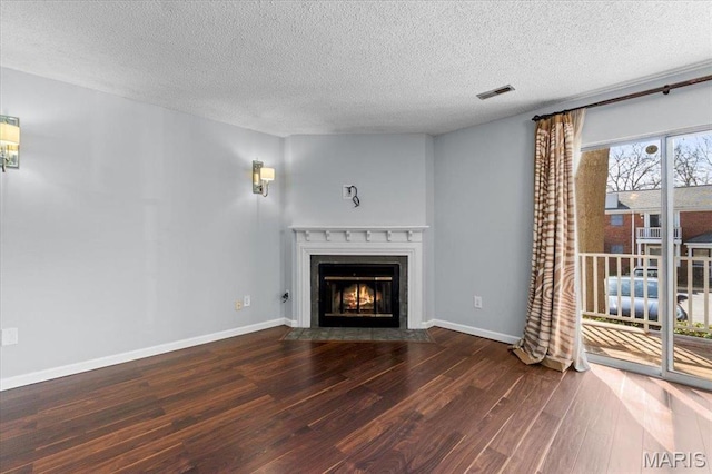1436 Peacock Ln, Saint Louis, MO 63144 - unfurnished living room featuring wood finished floors, a fireplace with flush hearth, a textured ceiling, and baseboards