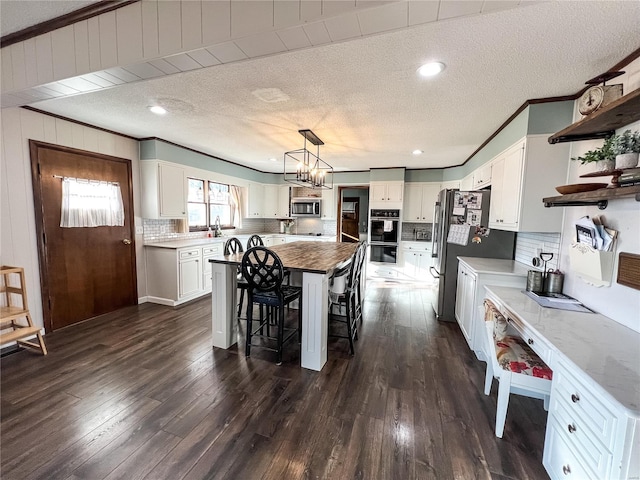 kitchen with stainless steel appliances, open shelves, decorative backsplash, white cabinetry, and a textured ceiling