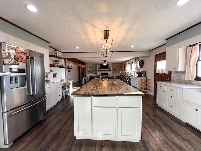 kitchen featuring stainless steel fridge with ice dispenser, a center island, white cabinets, recessed lighting, and crown molding