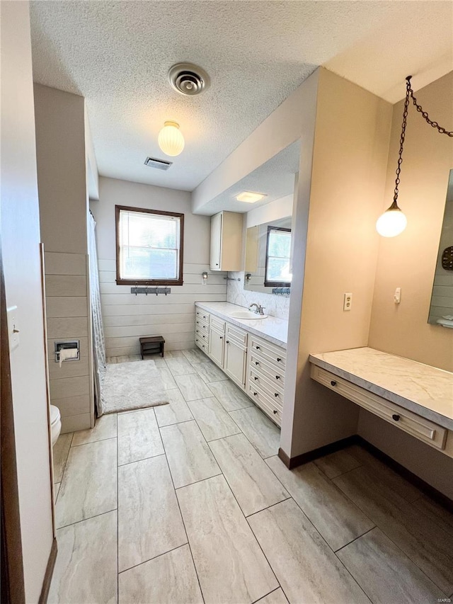 bathroom featuring toilet, vanity, a textured ceiling, and a shower with curtain