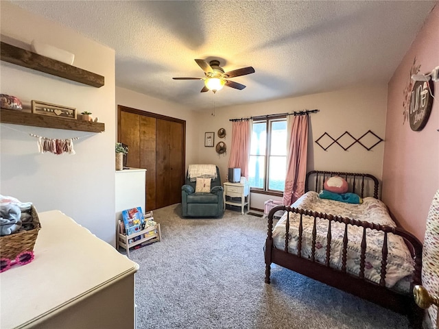 bedroom with carpet floors, a textured ceiling, ceiling fan, and a closet
