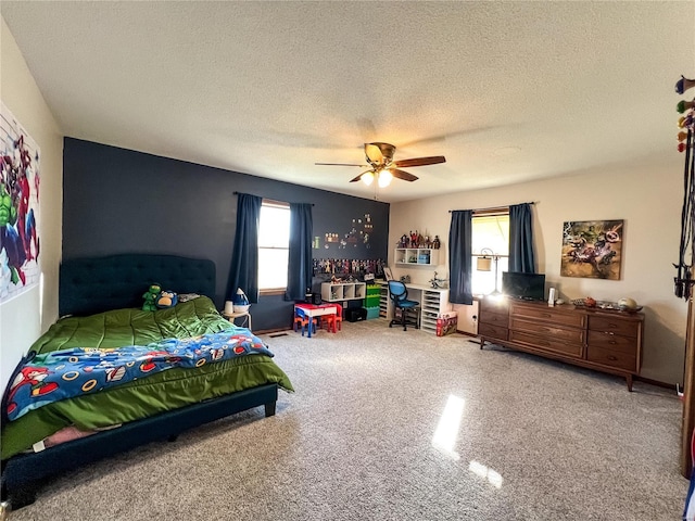 bedroom with a textured ceiling, ceiling fan, carpet floors, and an office area