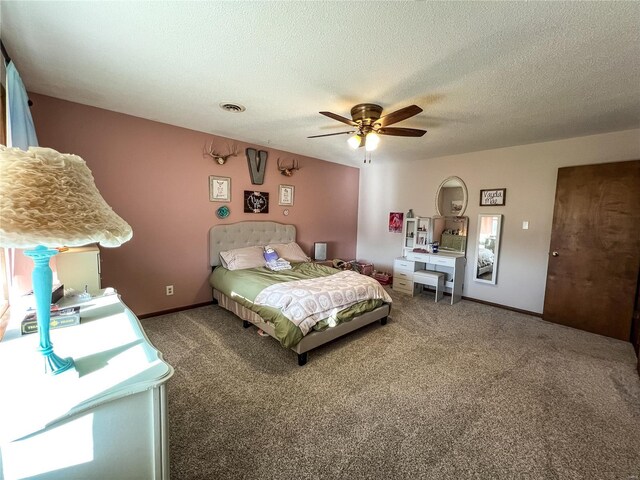 carpeted bedroom featuring ceiling fan and a textured ceiling