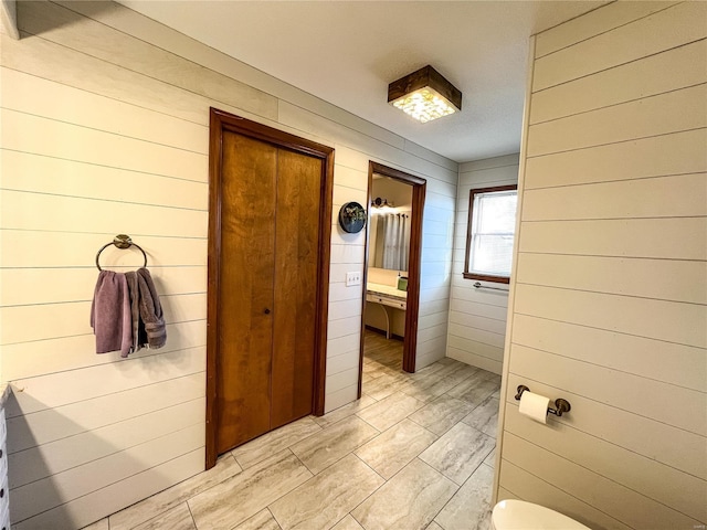 bathroom featuring wooden walls