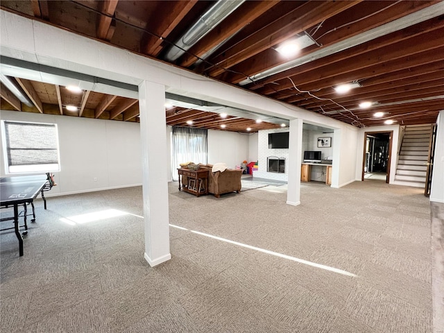 basement with a fireplace, carpet floors, and stairway