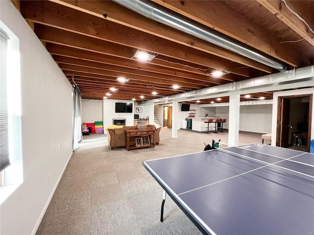 recreation room with a fireplace and baseboards