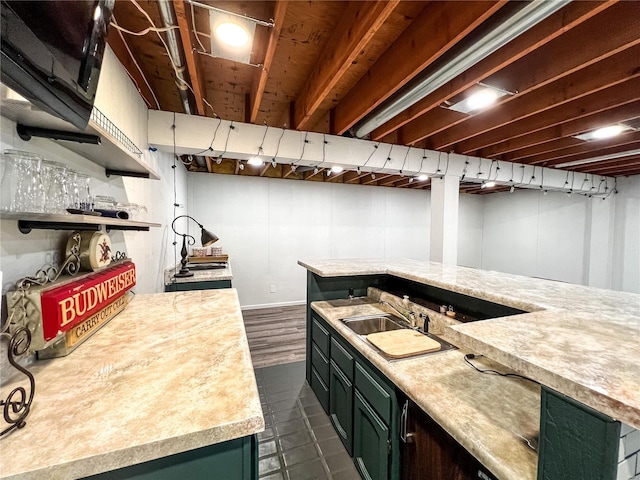 kitchen featuring light countertops, a sink, green cabinetry, and open shelves