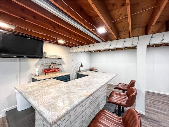 indoor bar with dark wood-style floors and baseboards