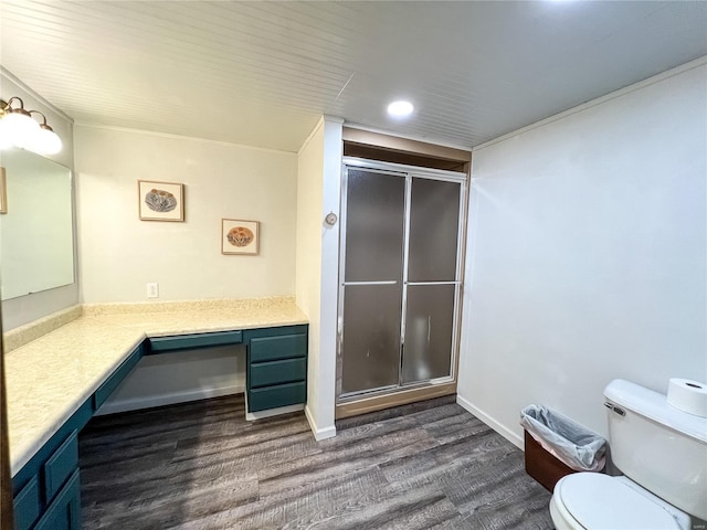 bathroom with wood finished floors, toilet, and a stall shower