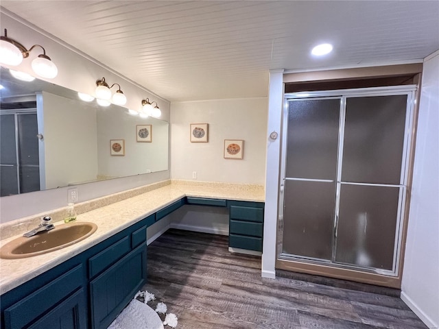 full bathroom with wood finished floors, a shower stall, and vanity