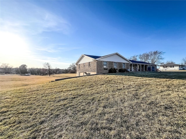 view of side of home with a lawn and brick siding