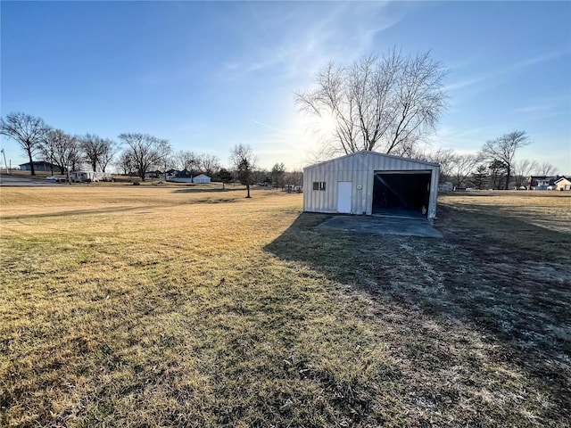 view of green lawn with a garage and an outdoor structure