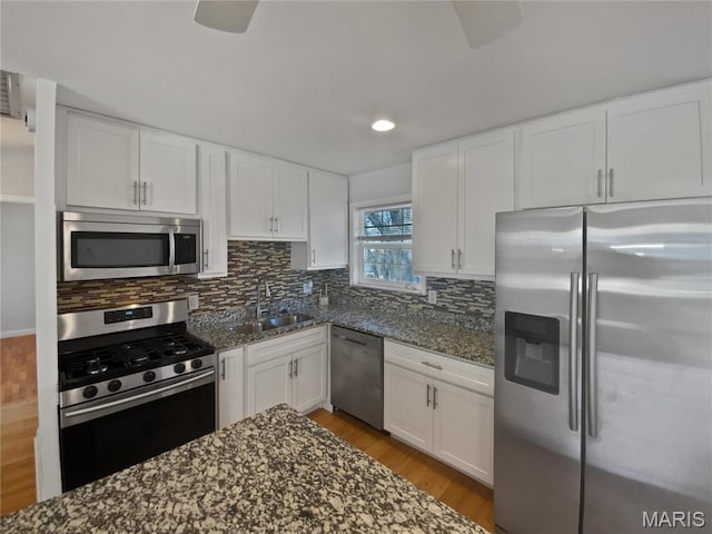 1248 Green Knoll Dr, Fenton, MO 63026 - kitchen featuring appliances with stainless steel finishes, a sink, dark stone counters, white cabinetry, and recessed lighting