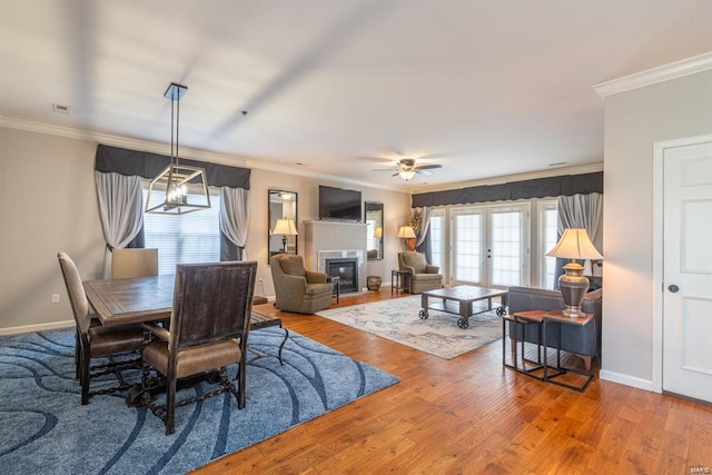 24345 State Route Ww Unit 40/41, Saint Genevieve, MO 63670 - dining room featuring crown molding, baseboards, wood finished floors, and a glass covered fireplace
