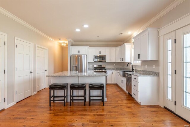 24345 State Route Ww Unit 40/41, Saint Genevieve, MO 63670 - kitchen with appliances with stainless steel finishes, a sink, ornamental molding, white cabinetry, and a kitchen bar