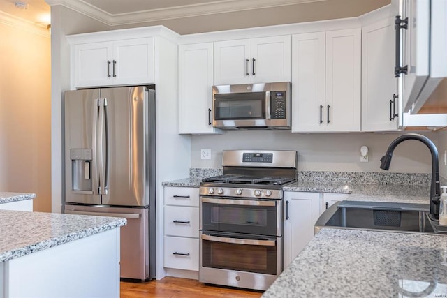 24345 State Route Ww Unit 40/41, Saint Genevieve, MO 63670 - kitchen with appliances with stainless steel finishes, crown molding, white cabinetry, a sink, and light stone counters
