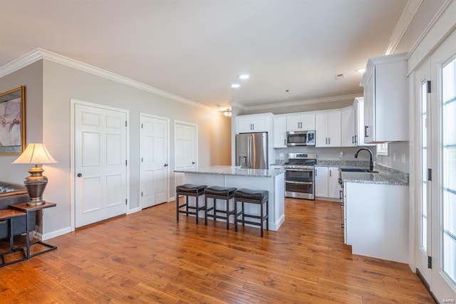 24345 State Route Ww Unit 40/41, Saint Genevieve, MO 63670 - kitchen featuring appliances with stainless steel finishes, a center island, a breakfast bar, white cabinets, and wood finished floors