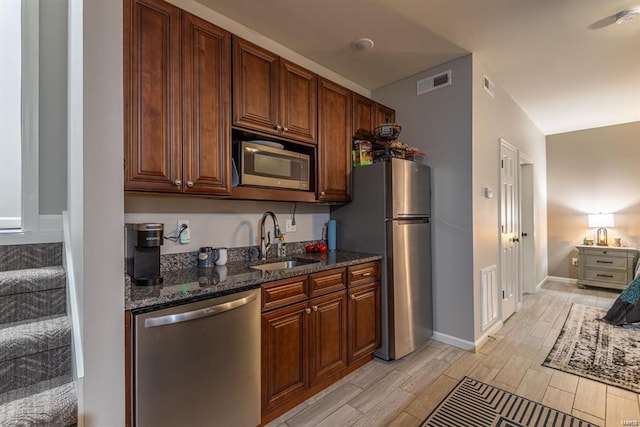 24345 State Route Ww Unit 40/41, Saint Genevieve, MO 63670 - kitchen with appliances with stainless steel finishes, a sink, light wood-style floors, dark stone counters, and baseboards