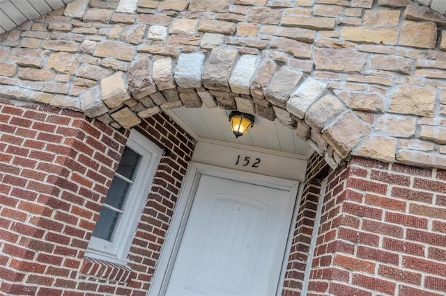 doorway to property featuring brick siding