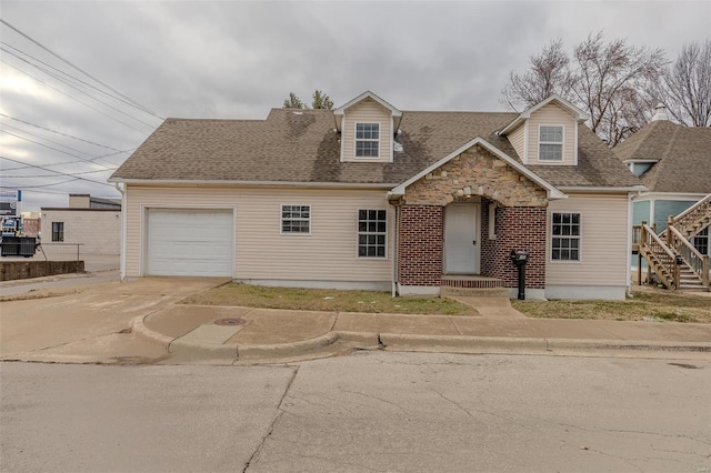 view of front of property featuring a garage, concrete driveway, and roof with shingles