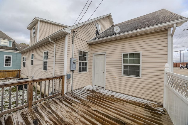 rear view of property with a deck and roof with shingles