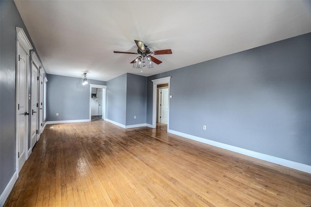 unfurnished room featuring ceiling fan, wood-type flooring, and baseboards