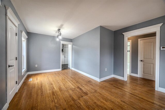 unfurnished room with wood finished floors and baseboards
