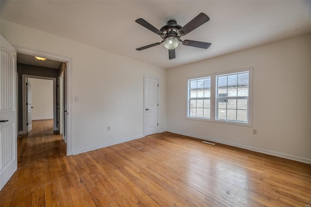 unfurnished bedroom featuring baseboards, wood finished floors, and a ceiling fan