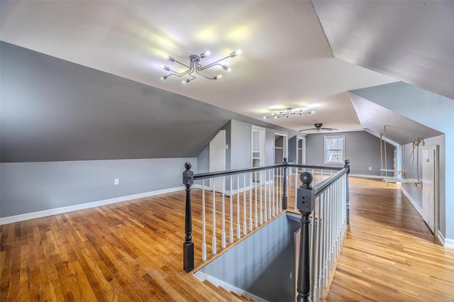 bonus room featuring lofted ceiling, wood finished floors, baseboards, and a ceiling fan